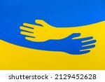 Small photo of Support for Ukraine. Embrace icon, arms hugging in colors of Ukraine , War in Ukraine, attack from Russia. Papercut, hands hug linear vector logo template. Care, love and charity symbol, hand papercut