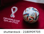 Small photo of QATAR, DOHA, 18 JULY, 2022: Official Adidas World Cup Football Ball Al Rihla. And logo of FIFA World Cup in Qatar 2022 on red carpet. Soccer sport background, edit space. Qatar 22 Wallpaper.