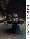 Small photo of A chocolate brownie, or simply a brownie, is a chocolate baked confection. Brownies come in a variety of forms and may be either fudgy or cakey, depending on their density.