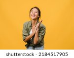 Small photo of Young Asia lady with positive expression, smile broadly, dressed in casual clothing and looking at camera over yellow background. Happy adorable glad woman rejoices success. Facial expression concept.