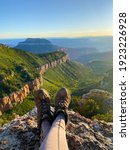 Small photo of A woman relaxes in the Kaibab National Forest on a ledge with a view of the Grand Canyon. This free hiking area is outside of the National Park in a less known area of the remote North Rim.