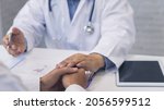 Small photo of Doctor holding patient's hand for encouragement, empathy, cheering and support while medical examination. Bad news lessening, medicine and health care concept.