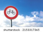 Small photo of Round bicycle sign transit prohibited for bicycles on a blue sky background. Bicyle road sign, prohibition red sign.