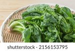 Small photo of Spinach on a bamboo basket. Japanese shrunken spinach.
