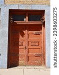 Small photo of Ancient rustic double doors with transom window and decorative hinges