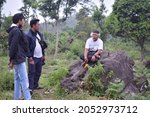 Small photo of Interview the old ascepas with his interludes sitting on a rock. Mount Arjuna. Pasuruan, Indonesia, October 5, 2021
