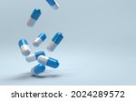 Falling pills on a blue background. Antibiotics. 3D render.