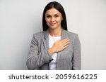 Small photo of I swear. Portrait of responsible serious businesswoman in business suit holding hand to take oath, promising to be honest, telling truth, pledging allegiance. Studio shot isolated on white background