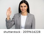 Small photo of Promise to tell truth. Portrait of woman raising hand to take oaths, promise to speak only truth, be sincere and honest, trustworthy evidence. Studio shot isolated on white background