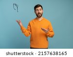 Young man wearing orange shirt throws glasses in trash isolated on blue background. Good vision concept. Stock photo 