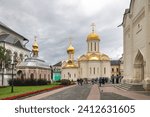 Small photo of Inner courtyard of the Holy Trinity-St.Sergius Lavra. View of the Trinity Cathedral with golden domes and the refectory with the Temple of Sergius of Radonezh, built of red brick with ornaments.