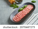 salami sausage on black plate grey background