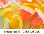Fresh slices of grapefruit, orange fruit and honey pomelo on white background. Pieces of grapefruit, orange fruit and honey pomelo in sparkling water on white background, close-up. Horizontal image.