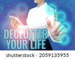 Small photo of Text sign showing Declutter Your Life. Business concept To eliminate extraneous things or information in life Lady In Uniform Standing Hold Phone Virtual Press Button Futuristic Tech.