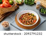 Small photo of Spicy Stir Fried Squid or Tumis Cumi Pedas is Indonesian traditional food, especially in javanese. served on plate and isolated gray background.