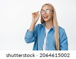 Carefree blond girl laughing, smiling and looking happy, put on glasses, standing in casual outfit over white background