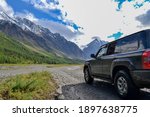 Off-road SUV car with Aktru mountain valley and glacier background. Adventure travel concept. Adventure tourism. Nature landscape. Overland 4x4 journey concept.