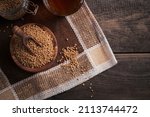 Small photo of Bowl of fenugreek seeds and Egyptian fenugreek yellow tea or Methi Dana drink on dark wooden background