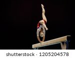 balance beam handstand female gymnast on black background