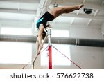 girl athlete gymnast exercises on uneven bars