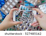 Female hand hold mobile smart phone taking photo of medicine pills