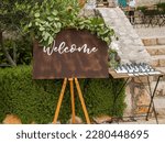 Small photo of Plaque with inscription greeting guests at wedding. Welcome inscription sign wedding decorations. Wedding decor outdoor marriage