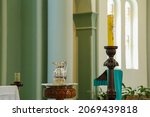 Small photo of Illustrative scene of baptism in a Catholic church with baptismal font, water jug, candles and paschal candle