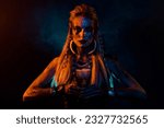 Small photo of Portrait of fantasy valkyrie woman make demonic ritual hold potion cup orange lights isolated on black background