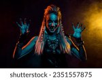 Small photo of Photo of dangerous valkyrie woman evil laugh arms fingers scare foggy mist orange light isolated on black background