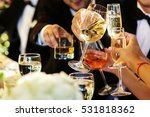 Small photo of People clang glasses sitting at dinner table in sparkling lights