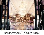 Look from afar at luxurious restaurant hall prepared for wedding dinner