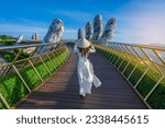 Vietnamese girl with traditional dress (ao dai) on Golden bridge at the top of the Ba Na Hills, Vietnam