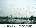 Rain Drops Falling down on background mirror car view, High quality photo of Rain on Window Sky Drops, Close up Slow Rain, Rainy day, Heavy Rainfall. Raining in car traffic.