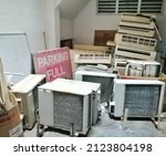 Small photo of unfocused image of a bunch of old, wasted and unused air conditioner compressor at an old building with signboard parking full. recycle item. junk item.