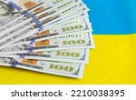 Small photo of Dollars on the background of the Ukrainian flag. War in Ukraine. Financial aid and support from all over the world. Investments in the country. Lend-Lease. Donations.