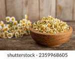 Dry chamomile flowers on a wooden table. Soothing chamomile tea. Herbal drink. flat layout. Space for text.Copy space.Medical prevention and immune concept. Folk alternative medicine.