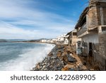 Small photo of Effects of climate change on the coast of the Pacific Ocean, houses on the verge of collapse due to sea level rise, rock barrier. Barra de Navidad, Jalisco, Mexico: 2 February 2024. costalegre