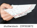 Tickets being held in a hand.