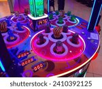 Small photo of A modern game of whack a moles in an indoor modern arcade center. Game concept. Technology, recreation. Carnival, festival, celebration. Bright neon light. Java, Indonesia - December 25, 2023