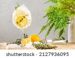 Small photo of Gin tonic alcoholic cocktail drink with dry gin, bitter tonic, lemon juice, thyme and ice, bar tools. Wooden table background with copy space