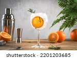 Small photo of Gin tonic orange cocktail, long drink with dry gin, bitter tonic, rosemary and ice, steel bar tools. Wooden table background with copy space