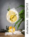 Small photo of Gin tonic lemon cocktail drink with dry gin, bitter tonic, juice, thyme and ice, bar tools. Wooden table background with copy space