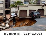 Small photo of Durban, South Africa, 22 May 2022. Two damaged cars that were abandoned when flooding caused a large landslide and destruction to occur.