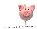 Close up of sweet pink marzipan cake pop pig with sweet overcoat as dessert and lucky charm for New Year on white background