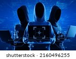 Internet security and personal data theft concept with blue shadows faceless hackers in hoody using laptop and abstract virtual technological symbols