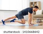 sport, fitness and healthy lifestyle concept - man with tablet computer doing running plank exercise at home