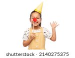 birthday, childhood and people concept - portrait of little girl in dress and party hat with red clown nose over white background