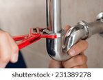 Closeup Of Plumber Fixing Pipe With Wrench