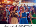 party, holidays, celebration, nightlife and people concept - happy friends with glasses of non-alcoholic champagne dancing at disco in nightclub
