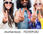youth culture, gesture and people concept - smiling young hippie friends in sunglasses showing peace hand sign outdoors